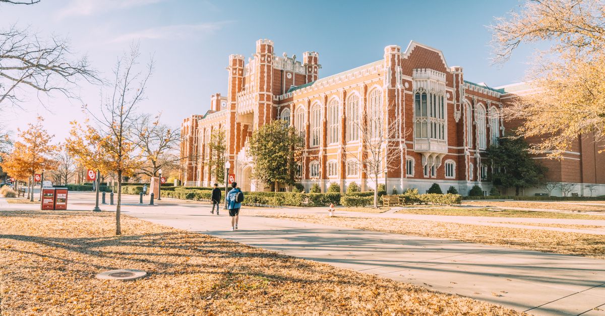 A scenic view of a historic university building surrounded by autumn foliage, reflecting academic architecture.